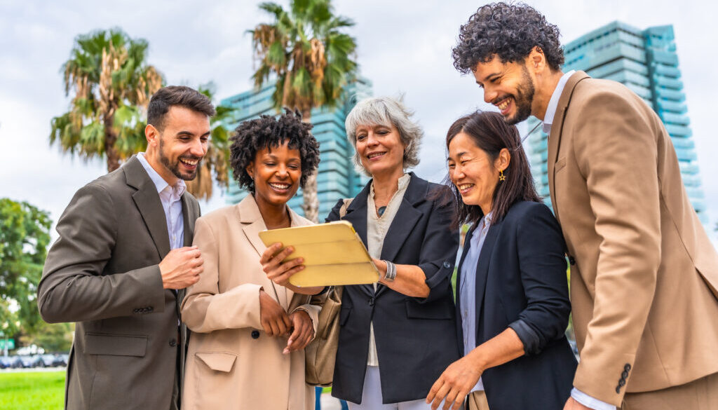 Multi-ethnic colleagues using digital tablet during outdoor business meeting
